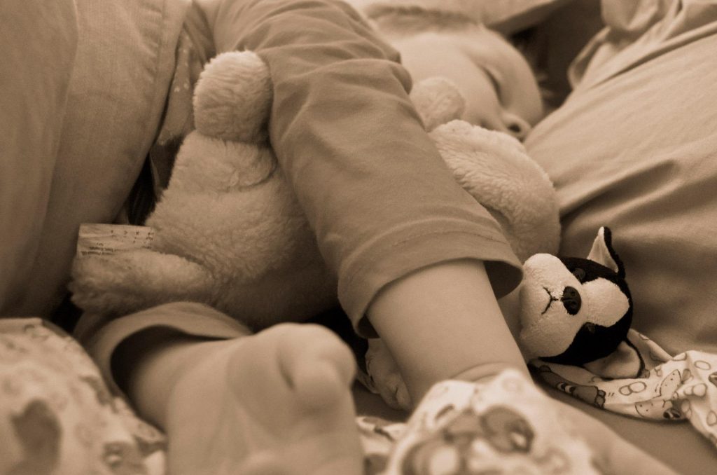 Baby schläft mit Kuscheltier